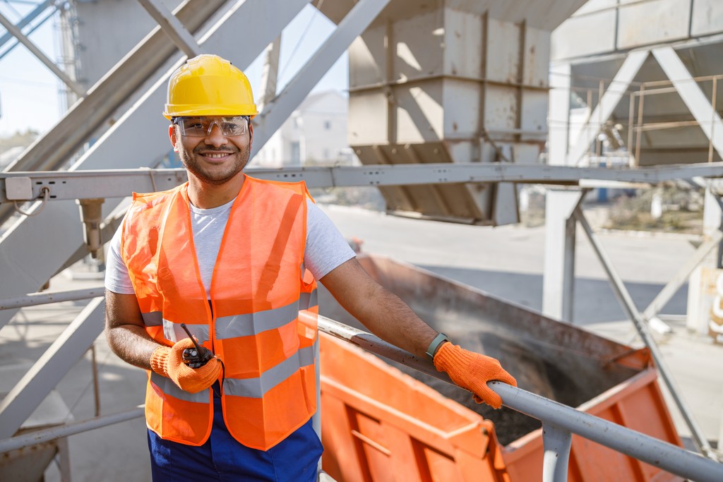man in blue white and red plaid button up shirt wearing yellow hard hat holding black